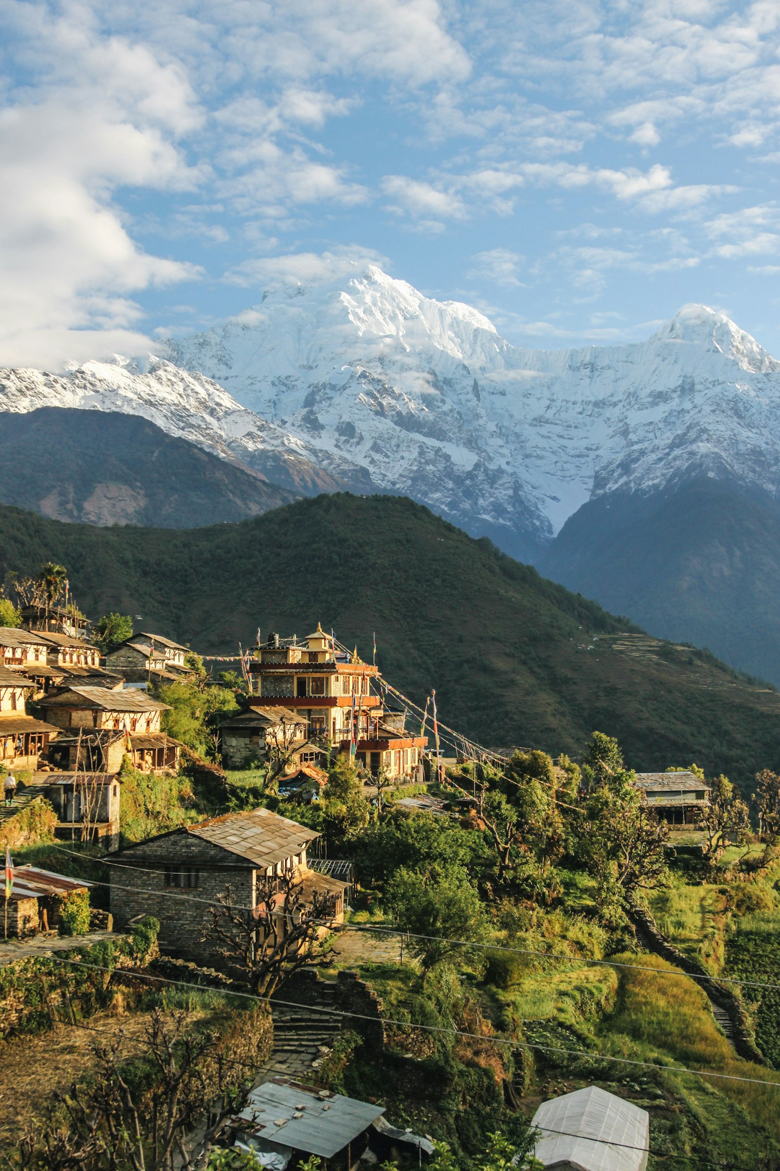 Himalayan village with snow-capped peaks behind, Nepal