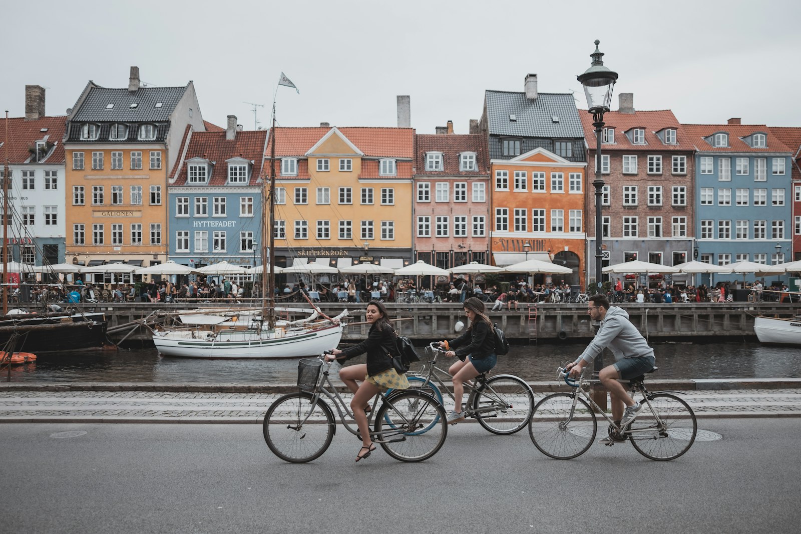 Cyclists passing colourful Nyhavn townhouses in Copenhagen, Denmark
